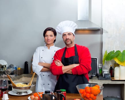 Chef couple man and woman posing in kitchen with uniform