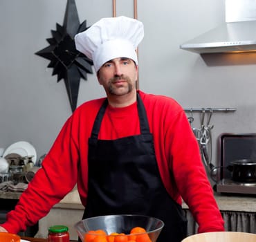 Chef man portrait with mustache in black and red on the kitchen