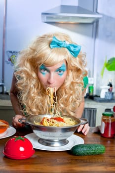 Blonde funny girl on kitchen eating pasta like crazy with blue makeup