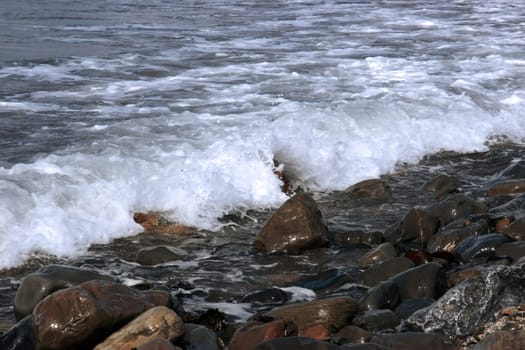 a pebbled beach on a warm day with a calm sea as a background