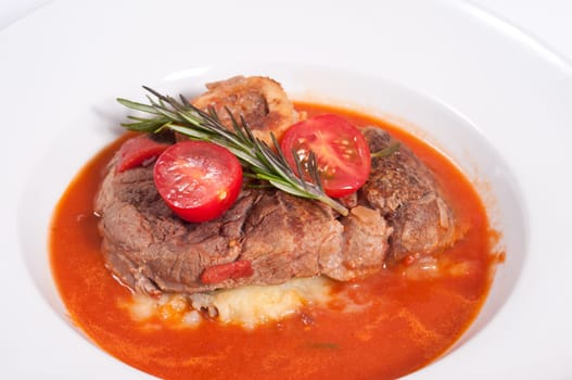 Braised osso buco with mashed potatoes,tomatoes and rosemary and tomato sauce