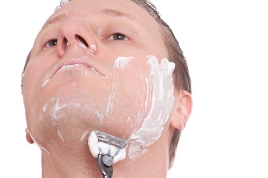 A man shaves wet with a razor blade