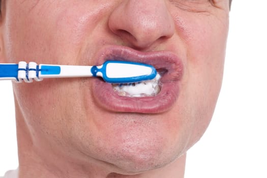 A European brushes his teeth with a hand toothbrush