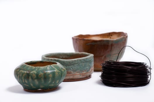 Three bonsai pots with colored glaze and copper wire to form a bonsai