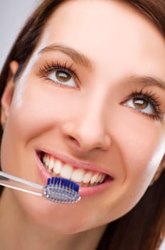 beautiful young woman brushing her teeth close up