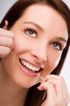 young Woman flossing teeth close up shoot