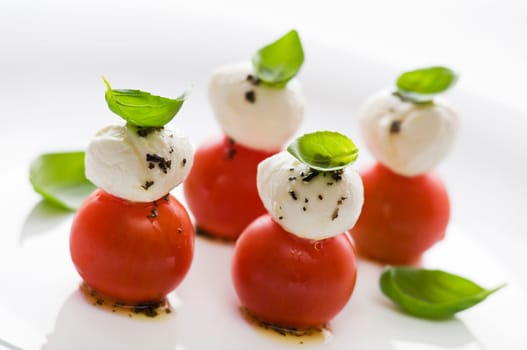 Simple snack with tomato, mozzarella and basil close up