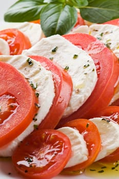 Sliced tomato and mozzarella with basil close up