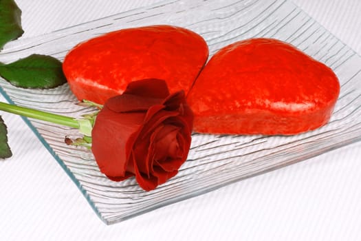 Two red heart shaped cakes and a rose for Valentine&#039 s Day