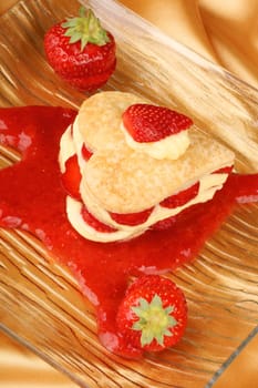Heart shaped strawberries and custard millefeuille on strawberry sauce. For a sweet Valentine&#039 s Day. Selective focus.