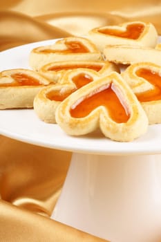 Close-up of some heart shaped apricot jam cookies for a sweet Valentine&#039 s day. Over a yellow background