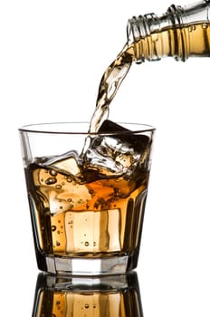 Whiskey being poured into a glass on white background