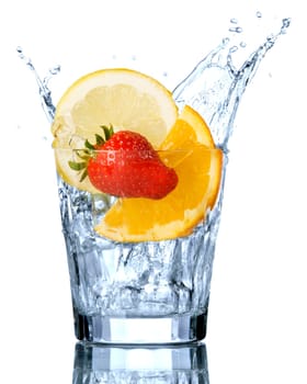 splashing orange, lemon and strawberry into a water glass
