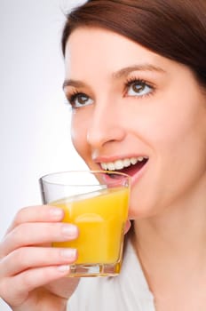 young brunette woman drinking orange juice close up