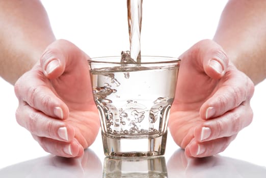 glass of fresh water between hands close up