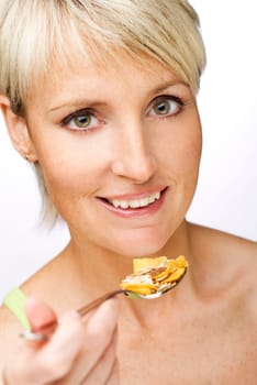 young blond woman eating corn flakes close up