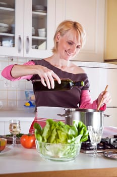 young blond woman cooking in the domestic kitchen