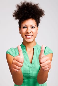 Beautiful woman with thumbs up. Studio shot.