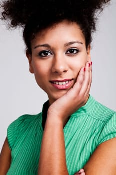 Portrait of a beautiful woman with hand on cheek. Studio shot.