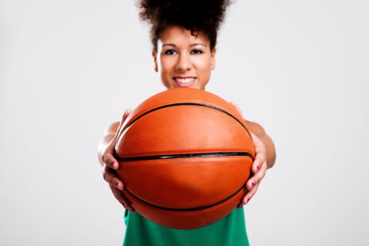 Beautiful athletic woman with basketball. Studio shot.