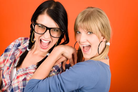 Two woman friends young have fun crazy smiling orange background