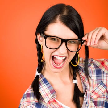 Crazy girl wear nerd glasses shouting on orange background