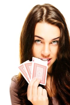 Young woman biting into poker card on white background