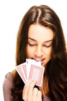 Young woman pulls a poker card with her teeth on white background