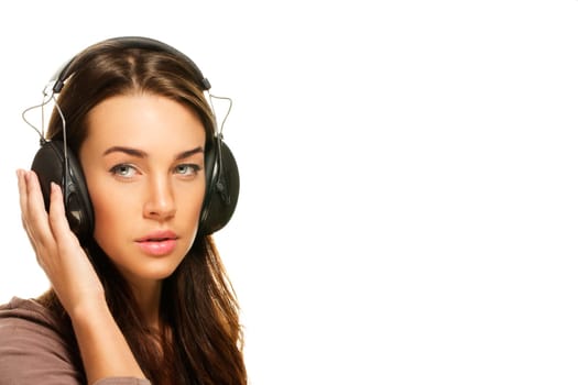 Young woman listening to music on white background