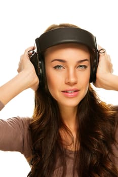 Young woman in headphones listening to music on white background