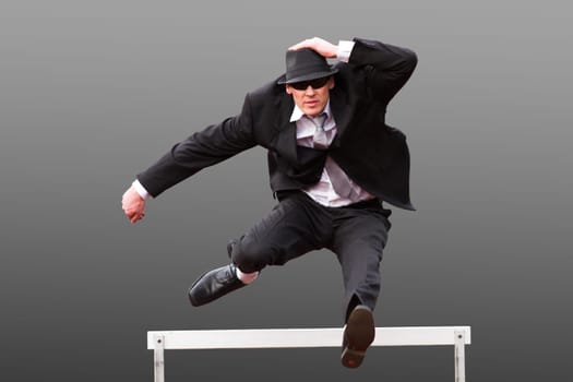 Businessman jumps hurdle