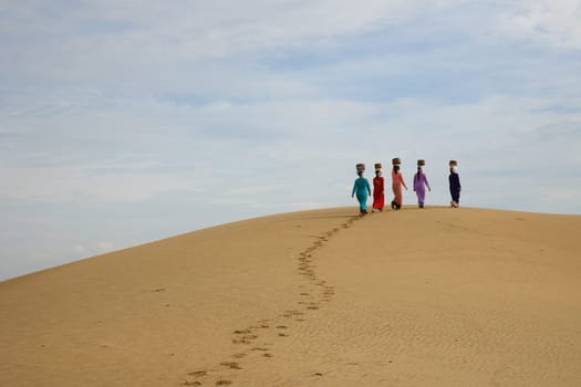 Walking women on the sand