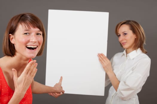 special offer or great deal - happy woman pointing with a finger on blank board