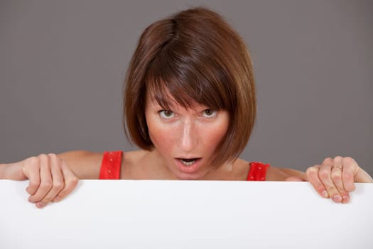 surprised woman with a white banner over grey background