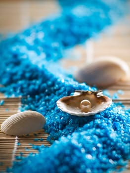 pearl in a shell on a blue salt close up