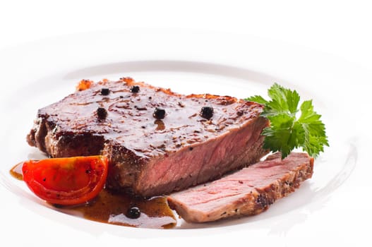 Fresh grilled beef steak on white plate close up