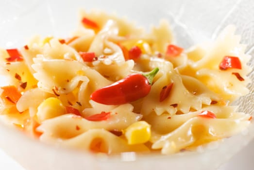 spicy salad with pasta, chili and corn close up