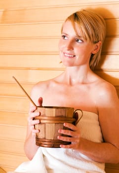 young blond woman relaxing in sauna close up