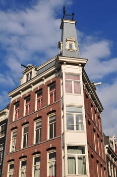 Corner building in Amsterdam (Netherlands) with traditional ancient bricks.