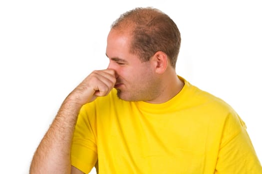 Young man holding his nose - isolated on white background