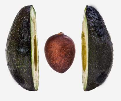 A split avacado suspended midair over a plate