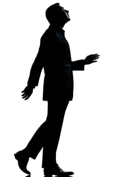 one caucasian business man walking looking up silhouette Full length in studio isolated on white background