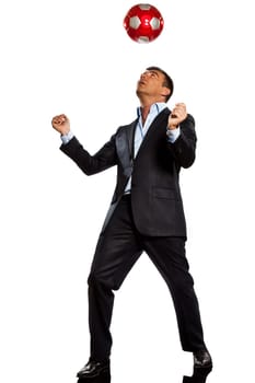 one caucasian business man playing juggling soccer ball in studio isolated on white background