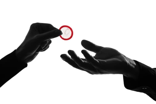 one caucasian couple man and woman hands holding tossing offering giving condom  in studio silhouette isolated on white background