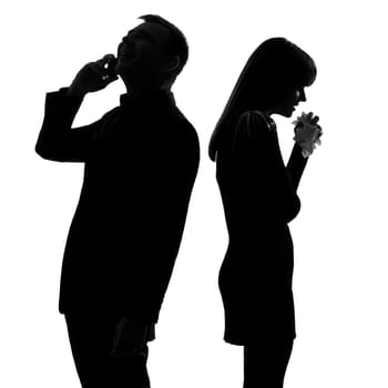 one caucasian couple standing back to back man on the phone  and woman crying in studio silhouette isolated on white background