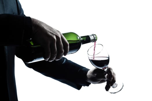 one caucasian man hands detail pouring red wine in a glass silhouette in studio isolated white background