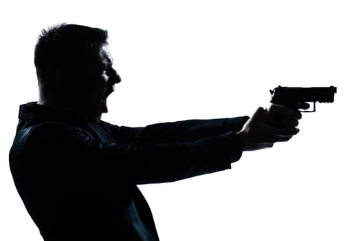 one caucasian spy criminal policeman detective man holding gun portrait silhouette in studio isolated white background
