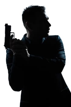 one caucasian spy criminal policeman detective man holding gun portrait silhouette in studio isolated white background