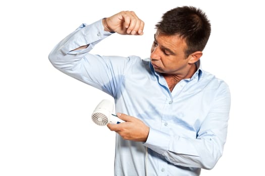 one caucasian man with sweat stain perspire drying shirt with hair dryer in studio isolated on white background