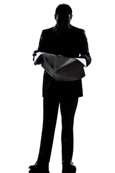 one caucasian man standing reading newspaper  full length silhouette in studio isolated white background